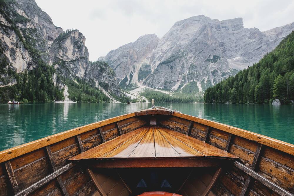 View from a boat on the emerald-green Lago di Braies and the nearby mountains